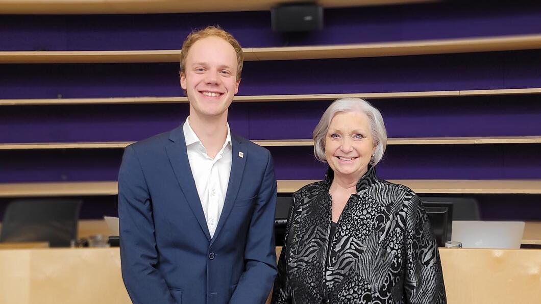 Julian Vosseberg(GL) en Marianne Spalburg(PvdA) staan glimlachend in de raadzaal van de gemeenteraad van Nieuwegein