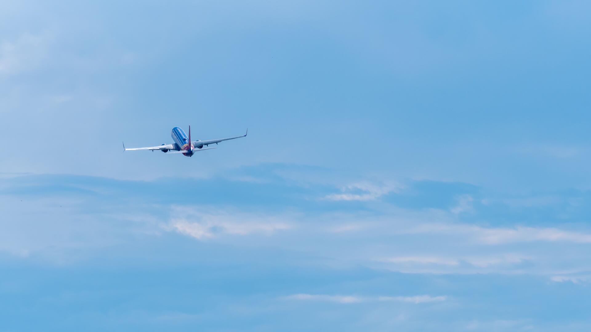 Blauwe lucht met in de verte een vliegtuig